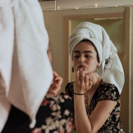 Girl with a towel on head in mirror