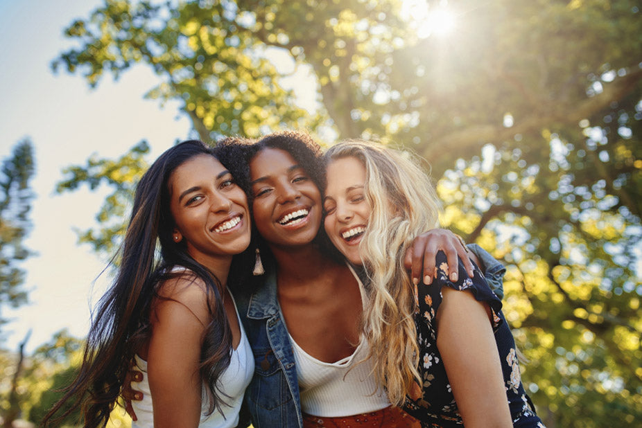 three smiling multiethnic young women