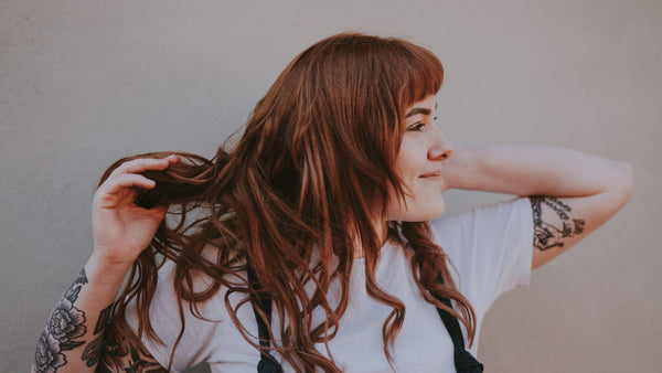 Woman twirling red hair in her fingers