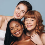 portrait of women with different skin tones smiling