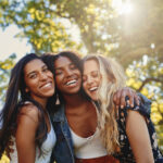 three smiling multiethnic young women